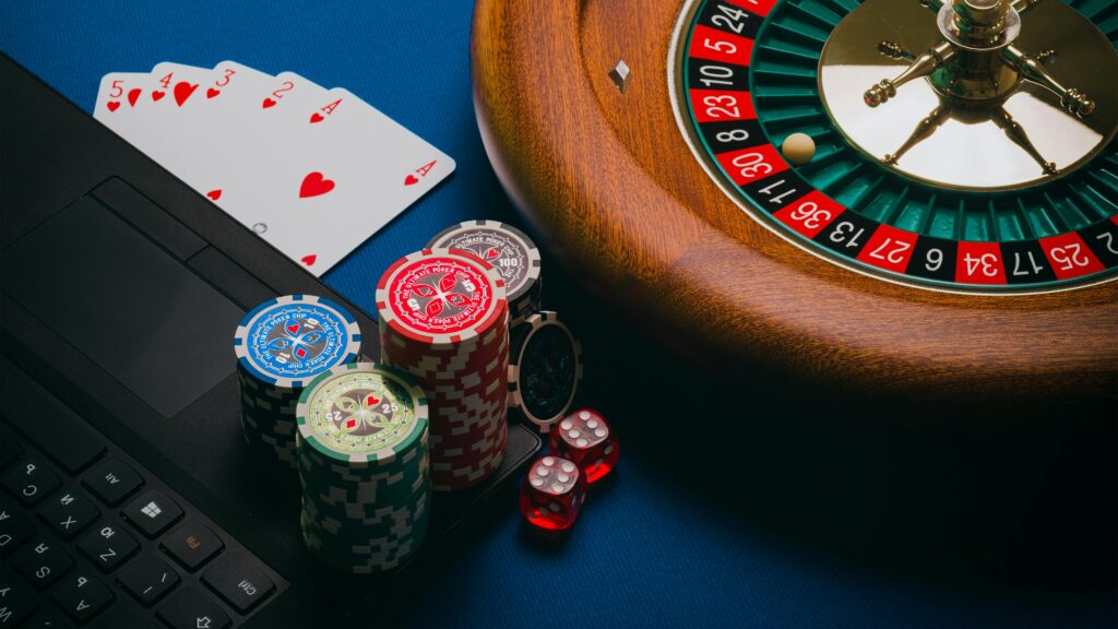 Close-up of a roulette table, poker chips, and playing cards depicting casino culture.